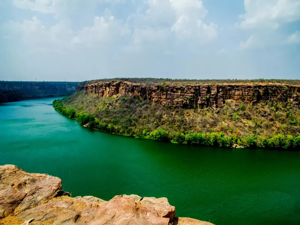 Green water of the Chambal river below sandstone cliffs near Kota