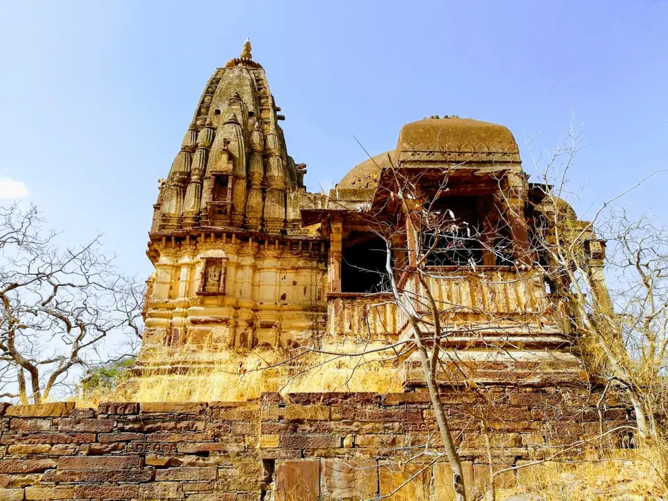 A stone temple with a carved spire inside Mukundara